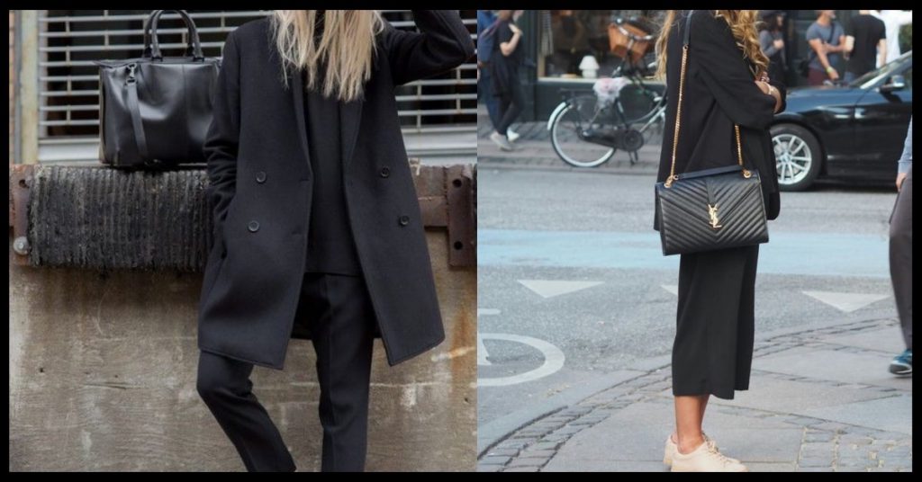 Two girls wearing all black outfits. One is wearing a long jacket and the other is wearing shot tailored pants.