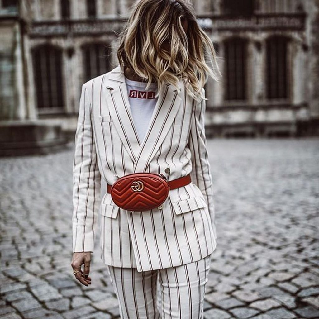 Girl wearing a white blazer with a Fanny Pack