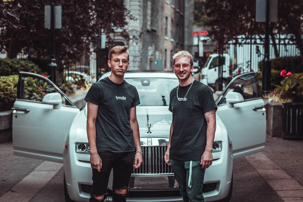 Two-hypebeasts-with-expensive-outfits-standing-in-front-of-a-rolls-royce-car-for-a-how-much-is-your-outfit-worth-video